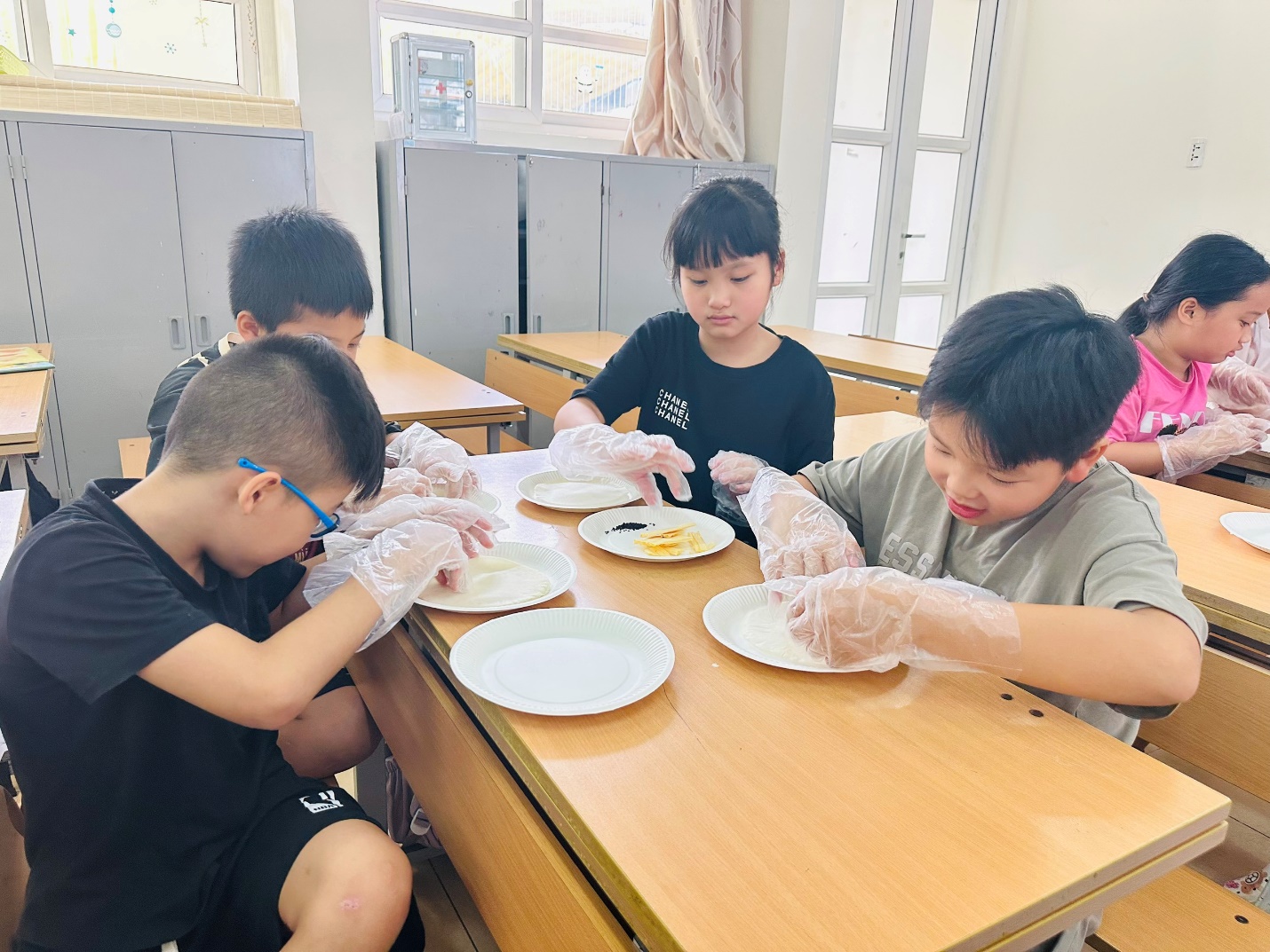 A group of kids sitting at a table with gloves on

AI-generated content may be incorrect.