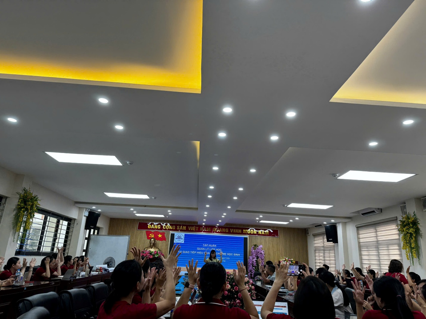 A group of people in a room with a stage and lights

AI-generated content may be incorrect.