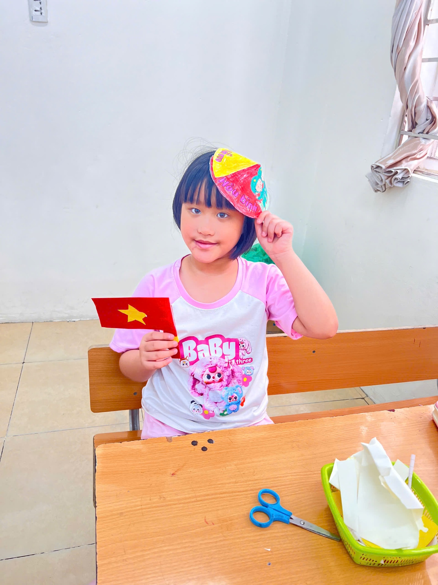 A child sitting at a table holding a paper flag

AI-generated content may be incorrect.