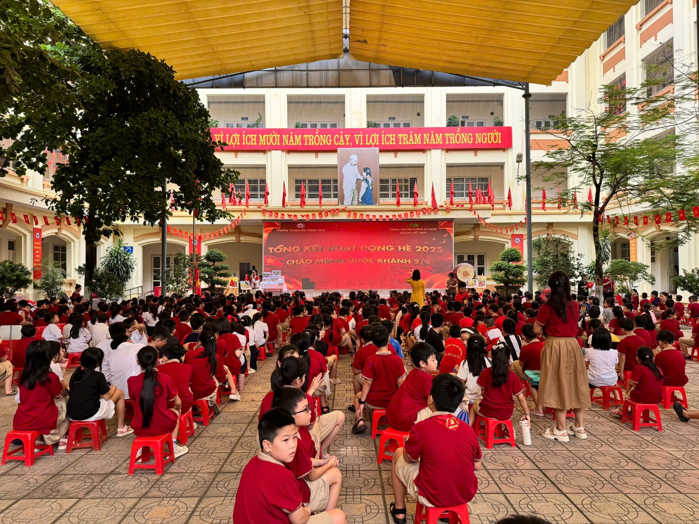 A group of children sitting in red chairs in front of a building

AI-generated content may be incorrect.