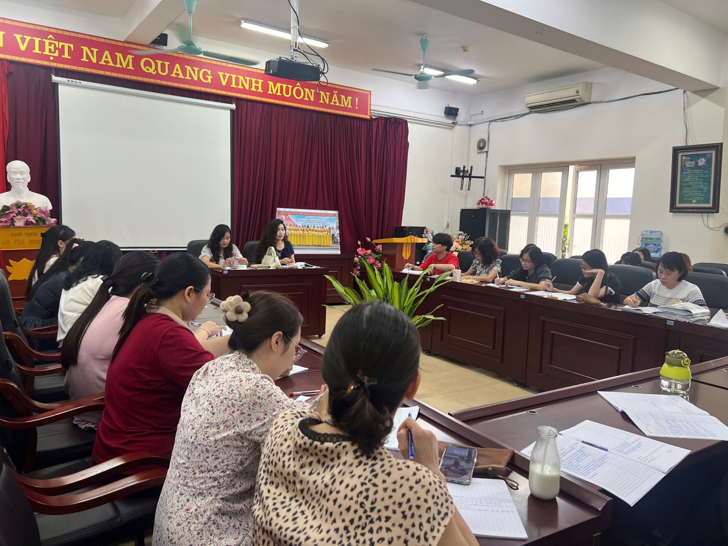 A group of people sitting in a room

AI-generated content may be incorrect.