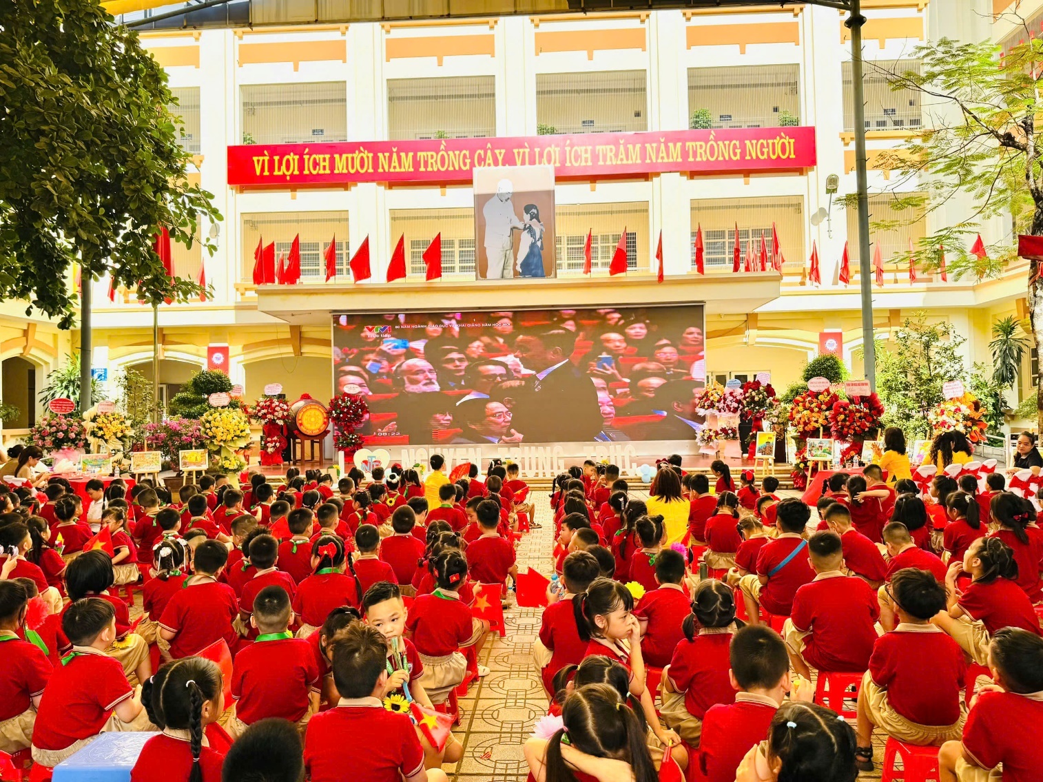 A group of children in red shirts sitting on the ground

AI-generated content may be incorrect.