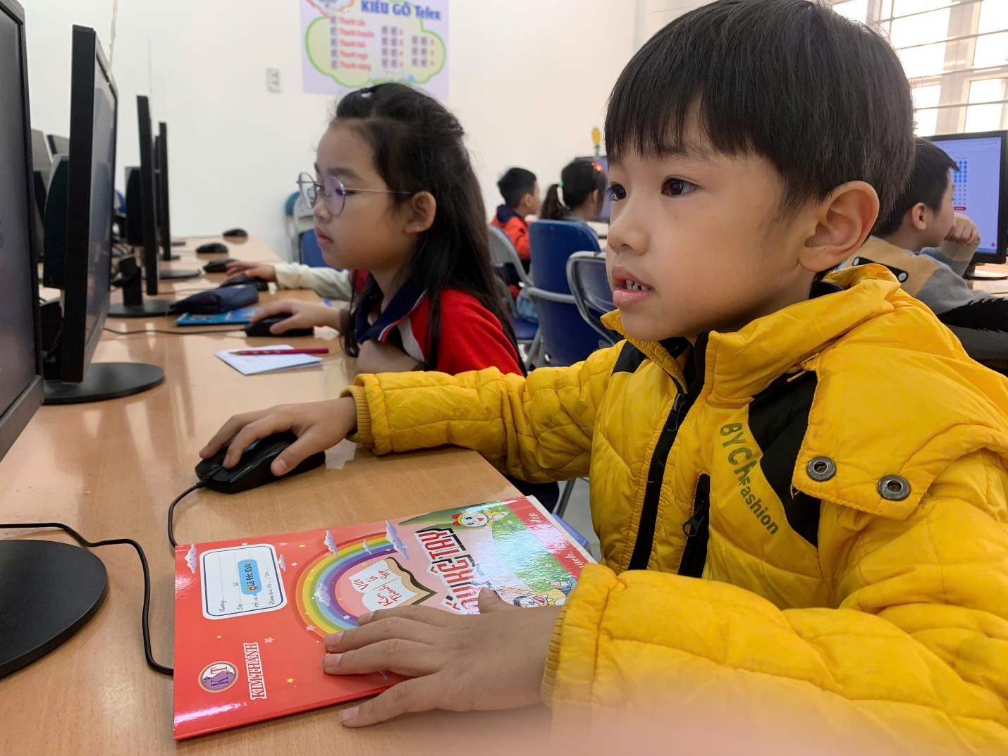 A child in a yellow jacket sitting at a desk with a mouse and a book

AI-generated content may be incorrect.