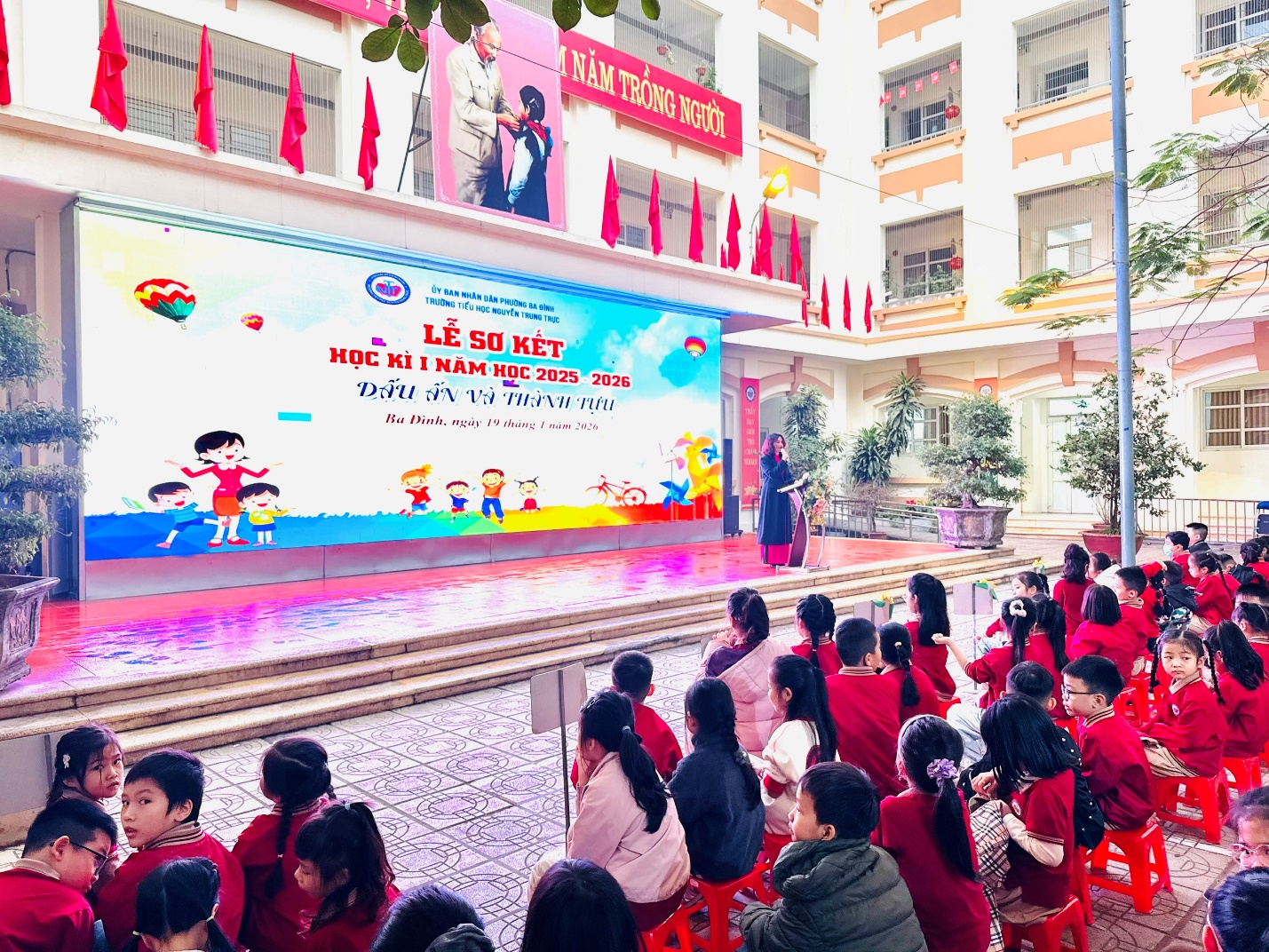 A group of people sitting on red chairs in front of a stage

AI-generated content may be incorrect.