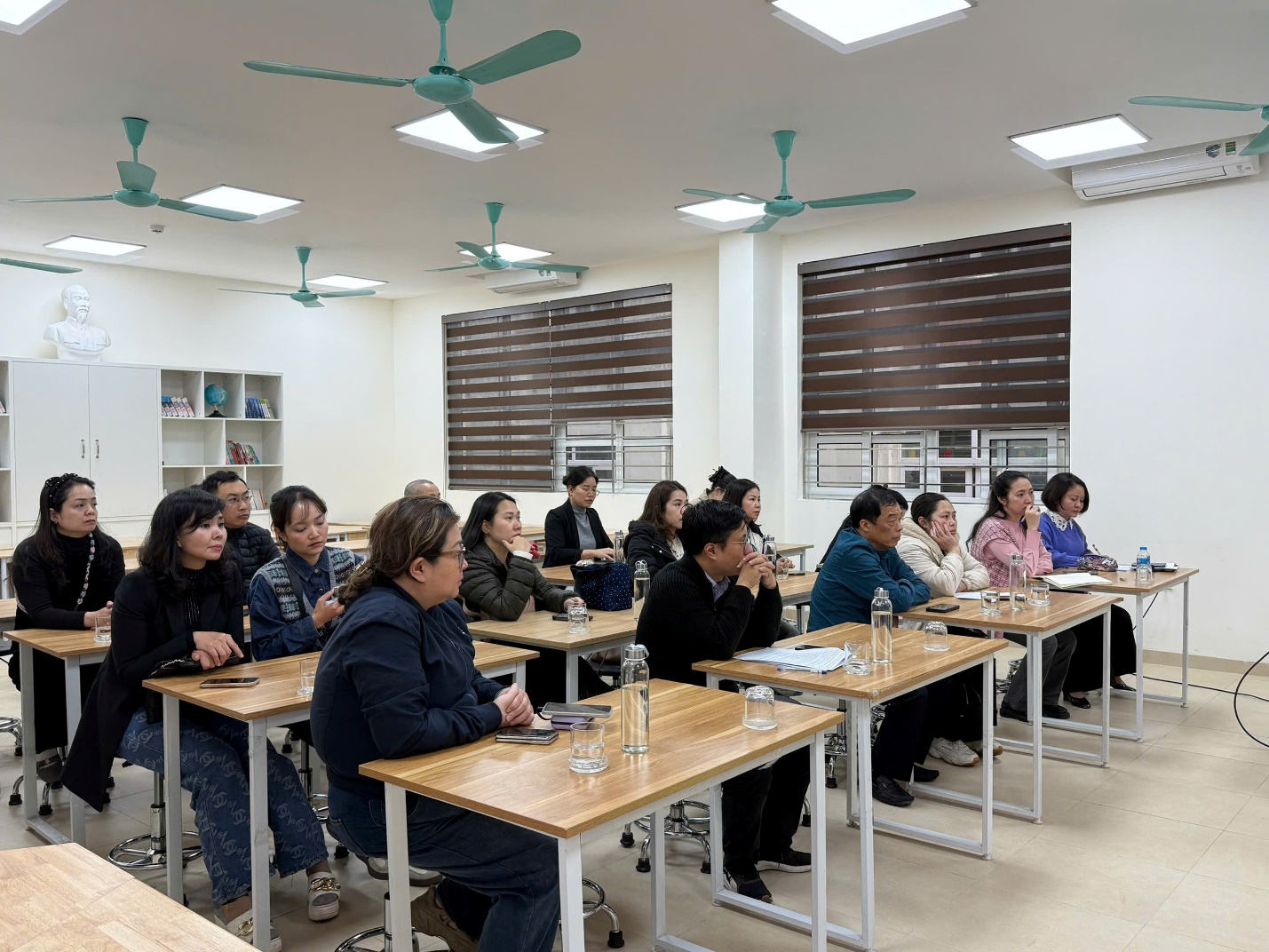 A group of people sitting at tables in a room

AI-generated content may be incorrect.