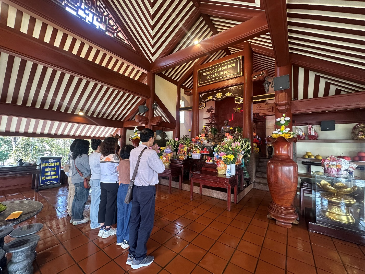 A group of people standing in a room with a shrine

AI-generated content may be incorrect.