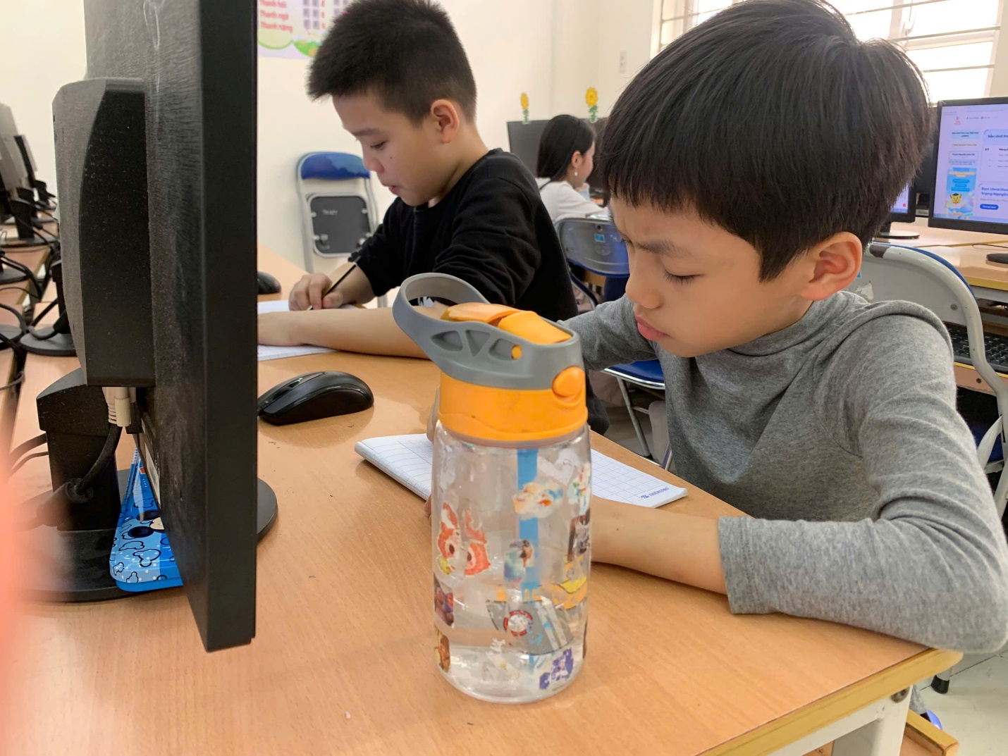 A child sitting at a desk with a bottle on it

AI-generated content may be incorrect.