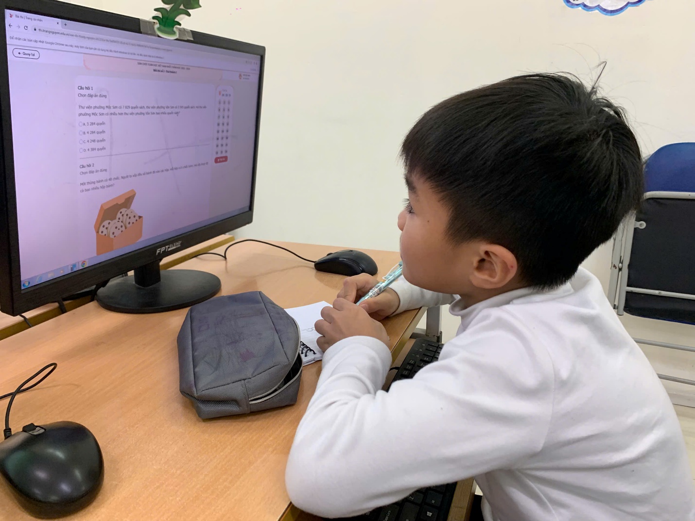 A child sitting at a desk with a computer

AI-generated content may be incorrect.