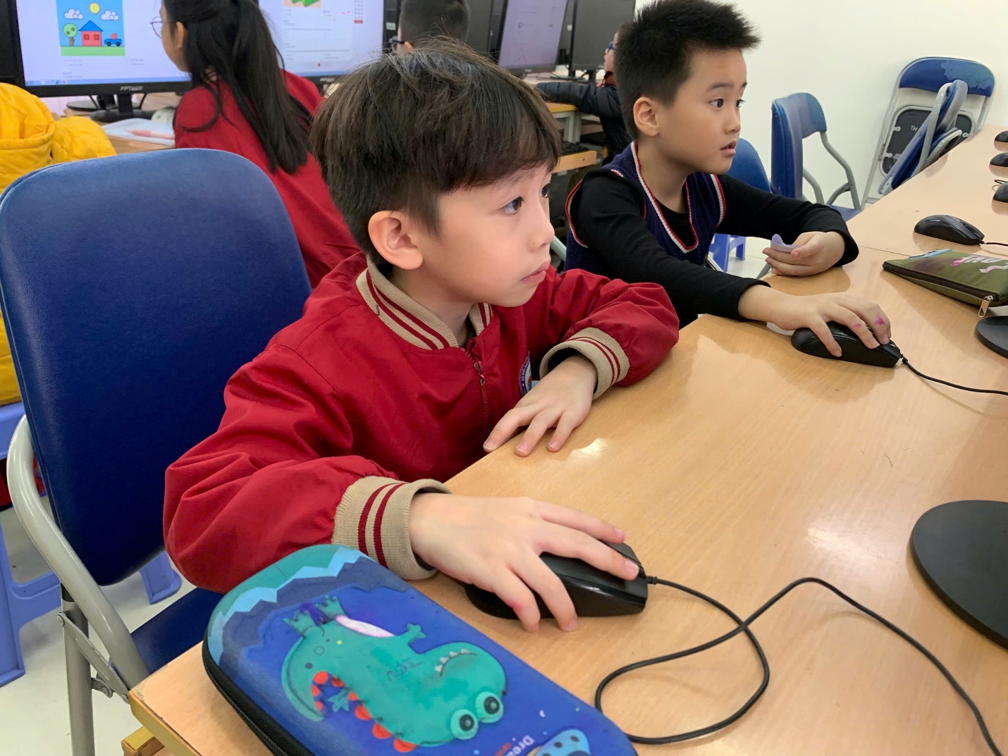 A group of kids sitting at a table using a computer mouse

AI-generated content may be incorrect.
