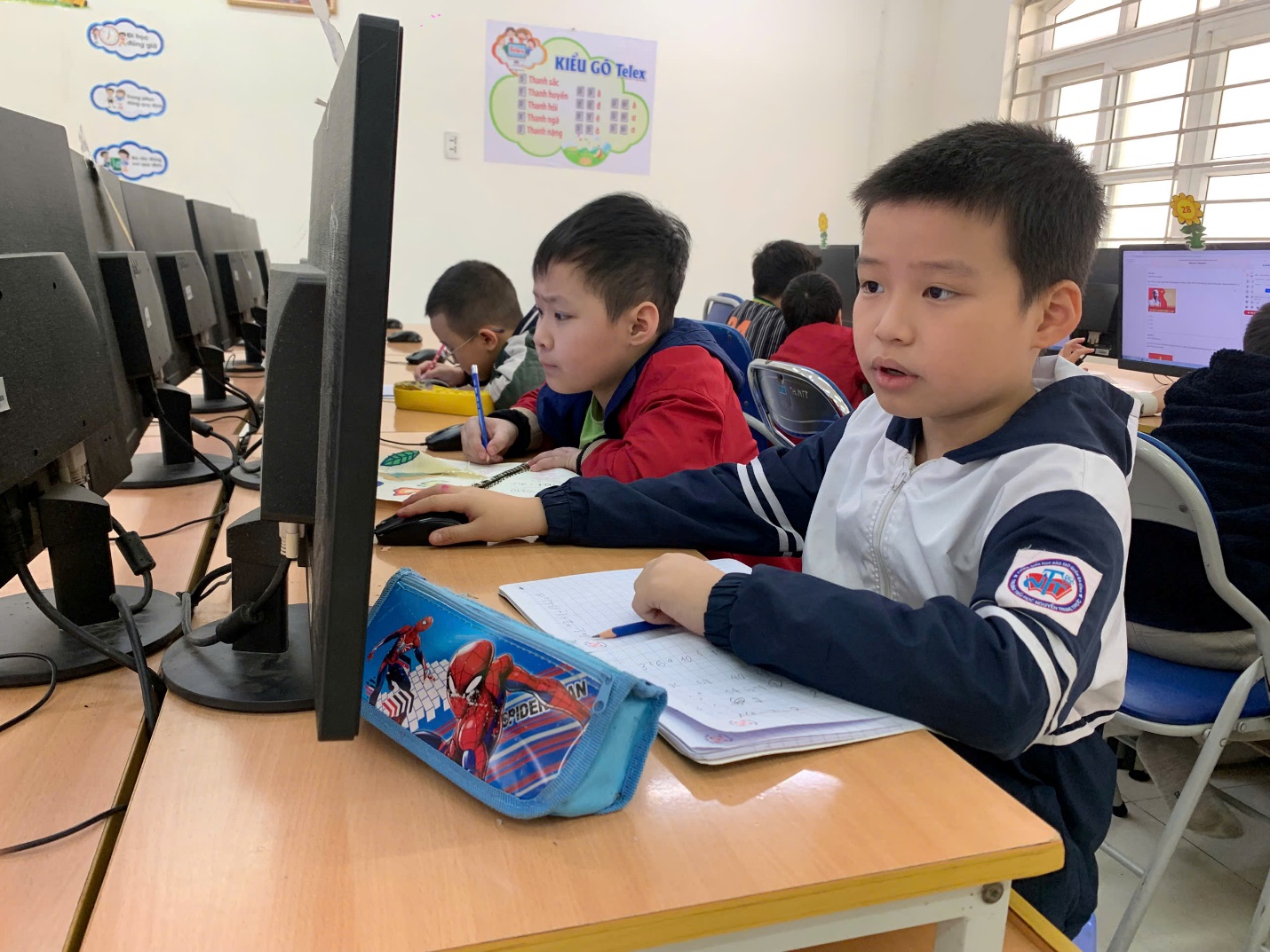 A group of children sitting at a desk in a classroom

AI-generated content may be incorrect.