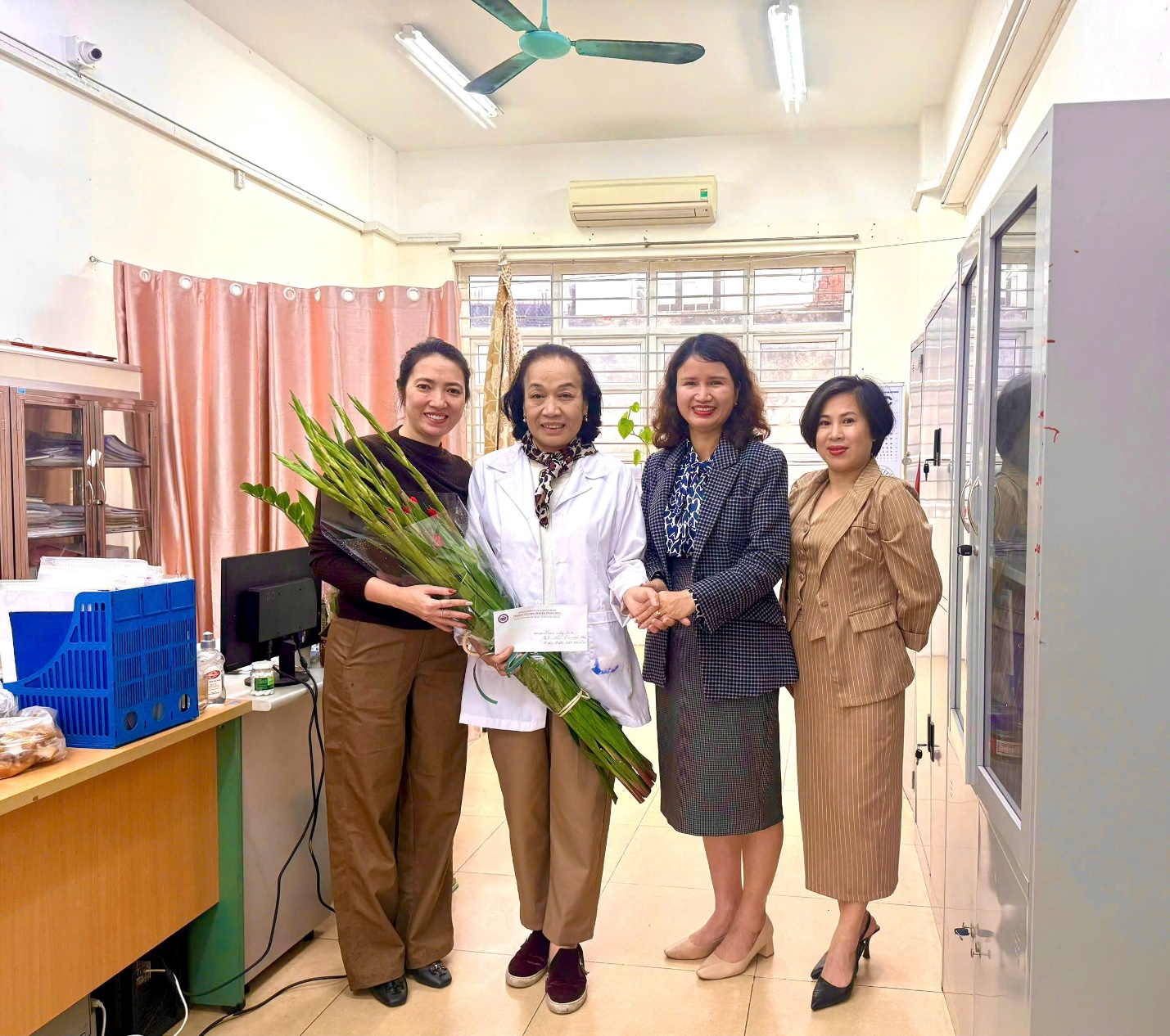 A group of women standing in a room with a bunch of flowers

AI-generated content may be incorrect.