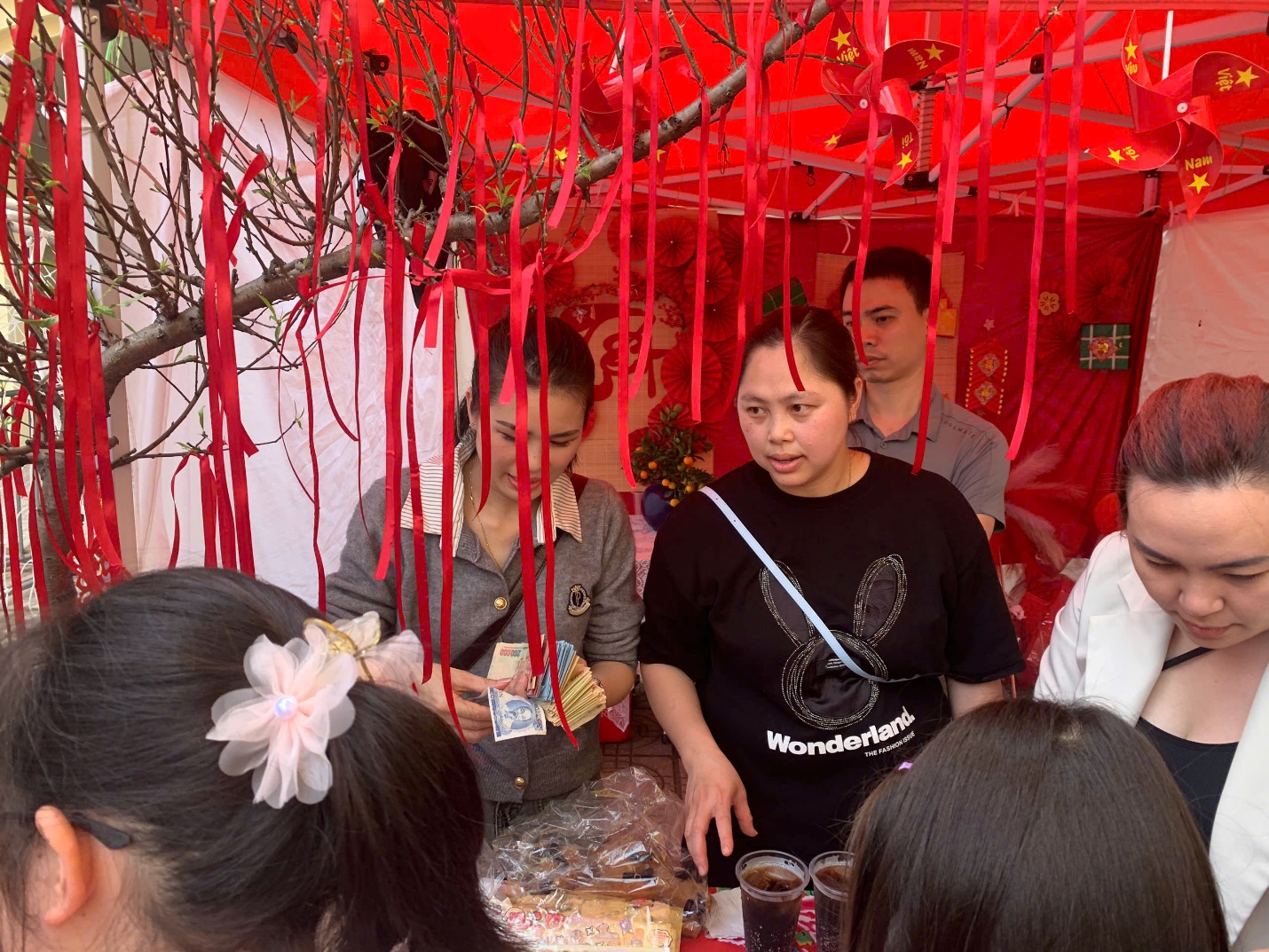 A group of people standing around a table

AI-generated content may be incorrect.