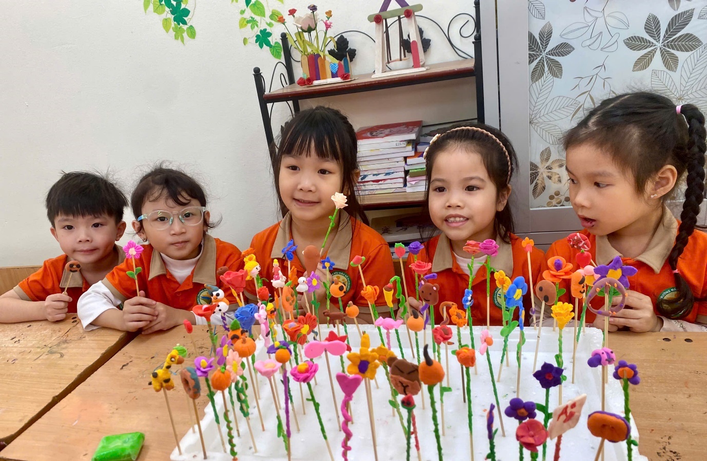A group of children sitting around a table with flowers

AI-generated content may be incorrect.