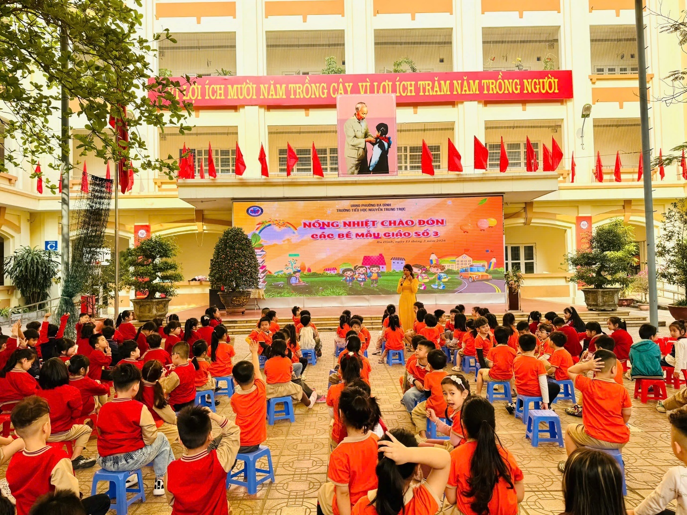 A group of children sitting on blue stools in front of a large building

AI-generated content may be incorrect.
