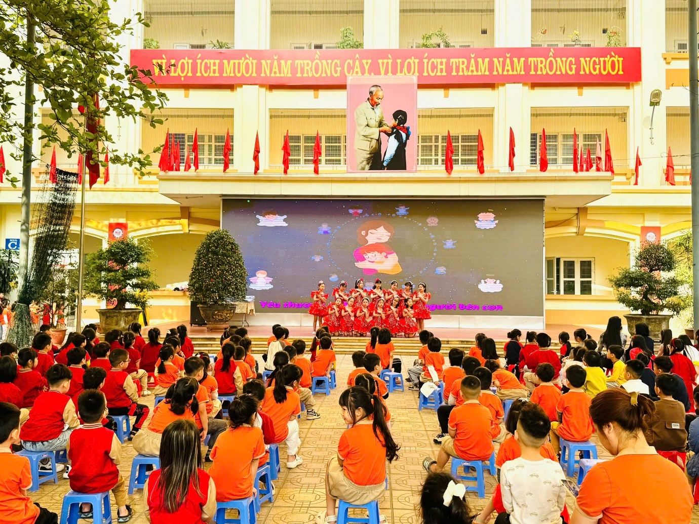 A group of children in a room with a stage

AI-generated content may be incorrect.