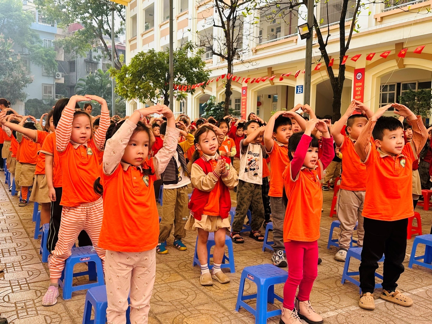 A group of children standing on blue stools

AI-generated content may be incorrect.
