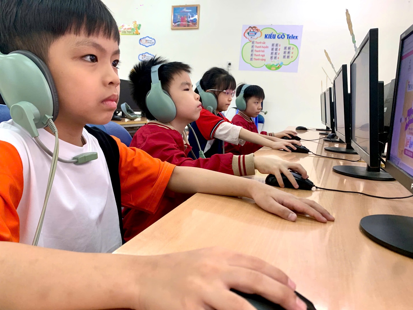 A group of kids sitting at a desk with computers
AI-generated content may be incorrect.